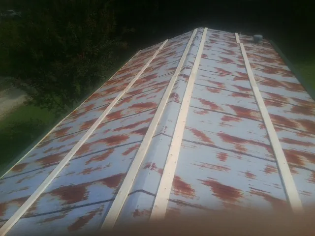 Rusted metal roof panels with new wood purlins before replacement — Storm Damage Roof Repair in Dillsboro by Roofing Brothers