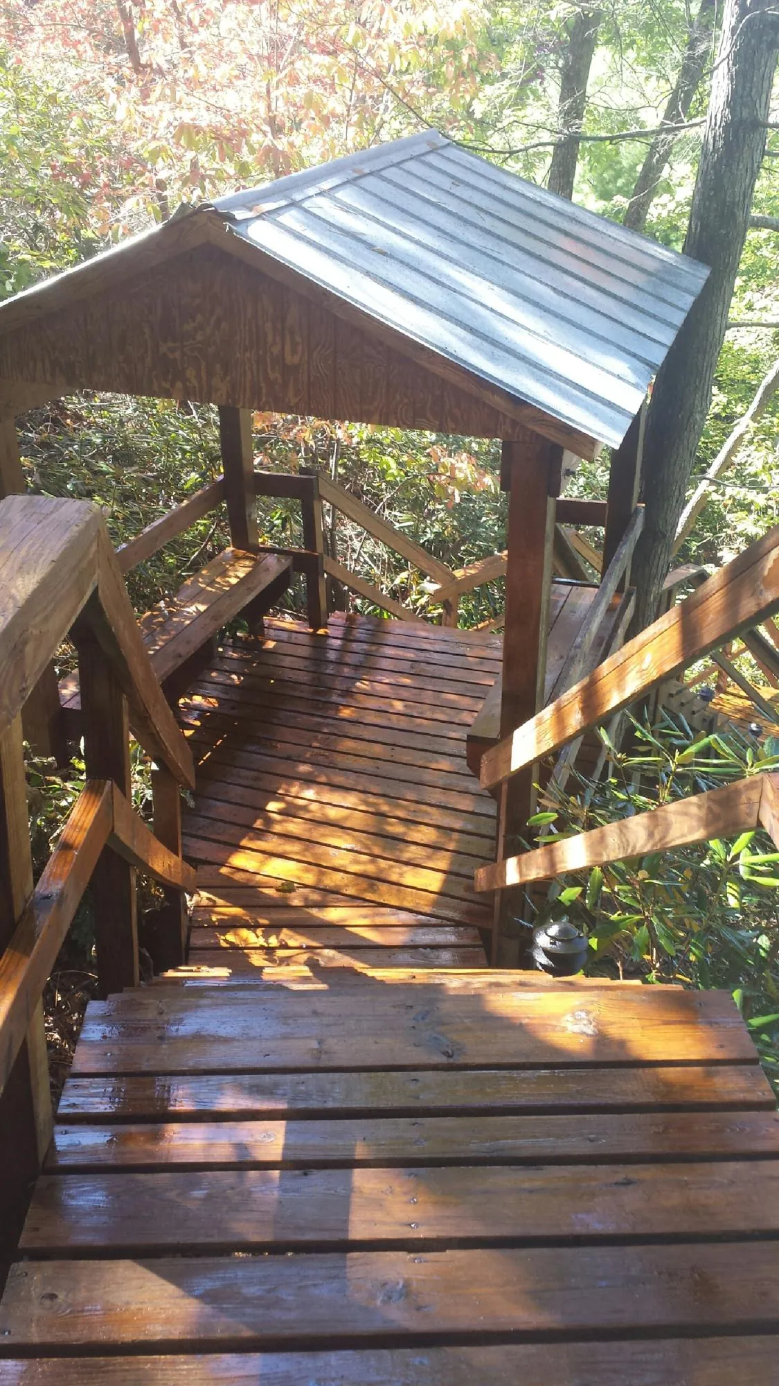 Freshly stained wood walkway and covered shelter with a metal roof in Dillsboro